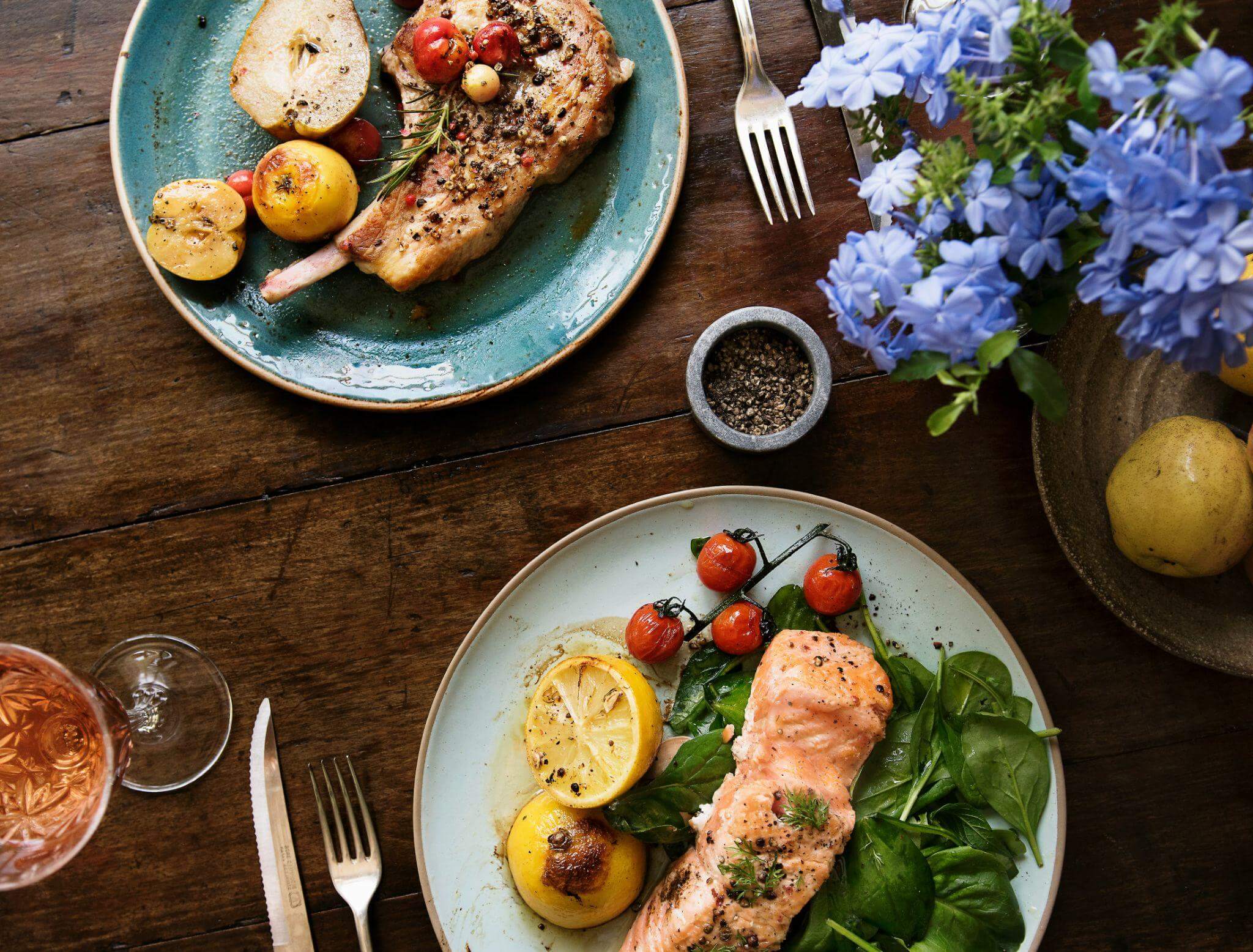 Blue plates with salmon and pork chop dinners showing what to eat