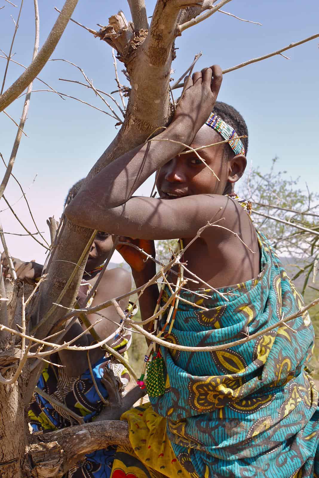 Two Hadzabe children in the shadow of a baobab tree