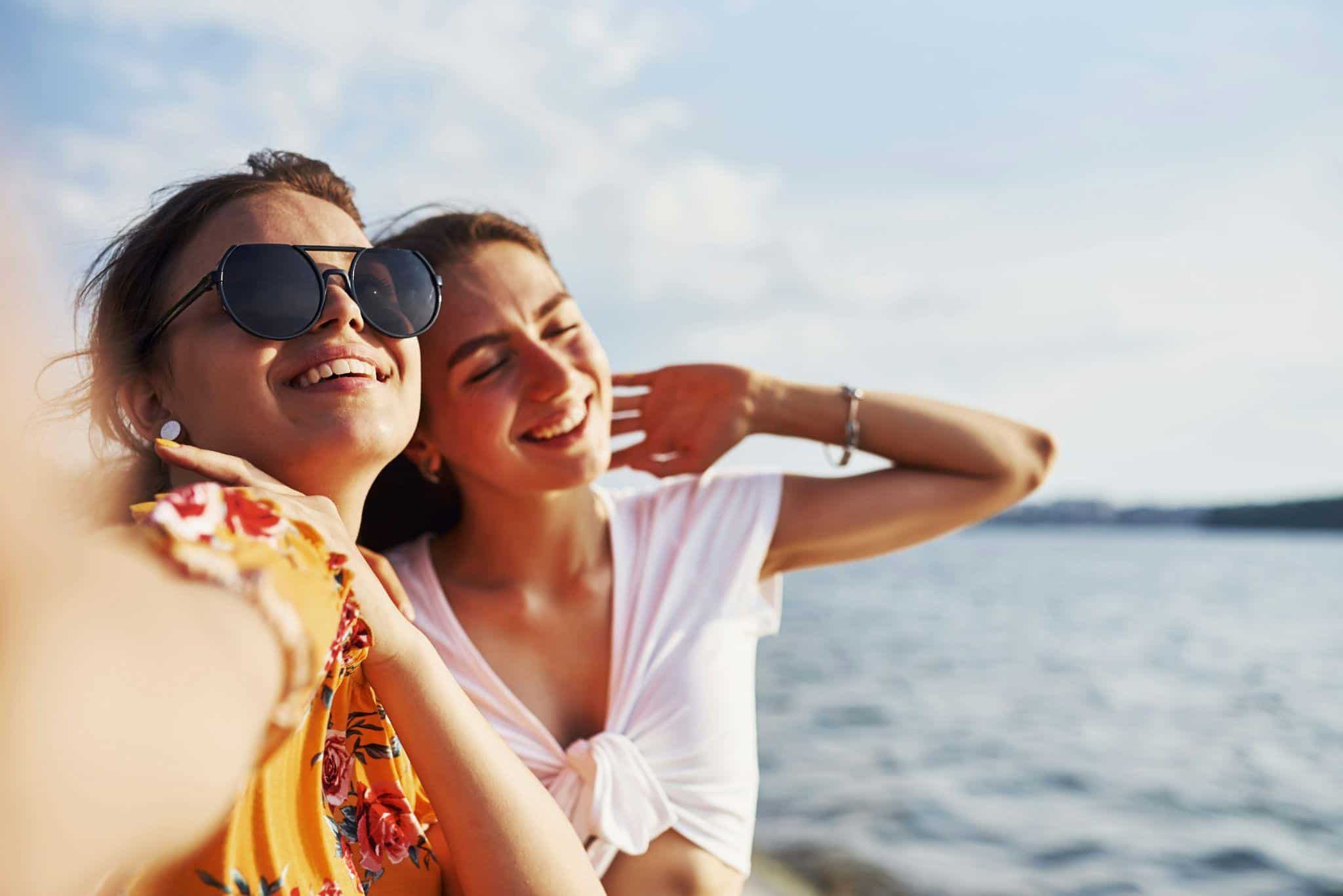 two friends taking a picture at the beach.